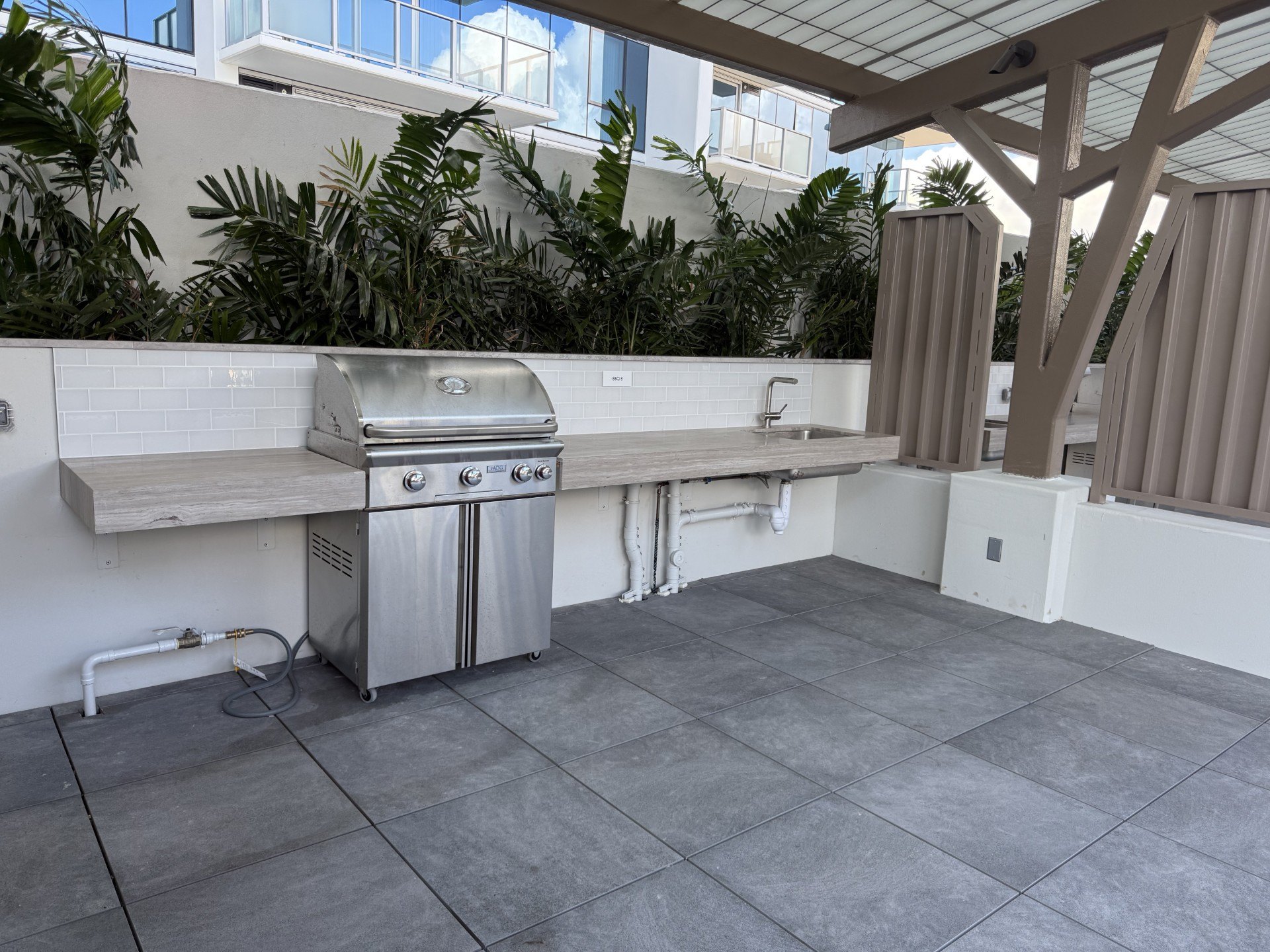 A patio with a grill and a table.